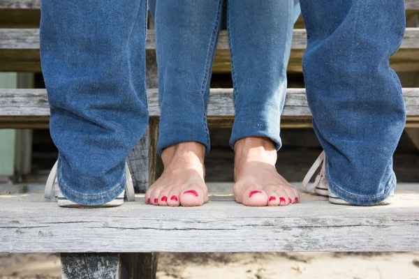 Босые ноги влюбленных женщин на деревянной лестнице — стоковое фото