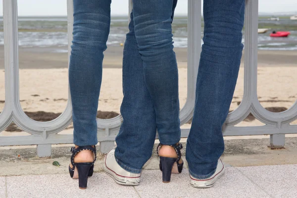 Pareja joven vistiendo jeans enamorados de pie en la calle — Foto de Stock