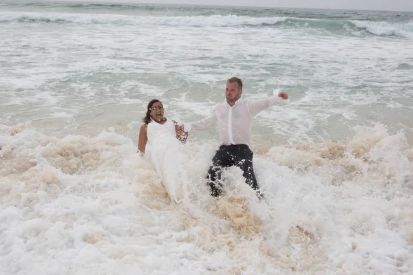 Wet lovely couple having fun in the ocean