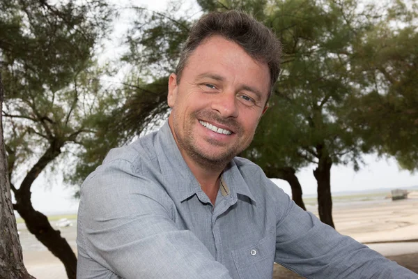 Portrait of middle-aged man standing against tree — Stock Photo, Image