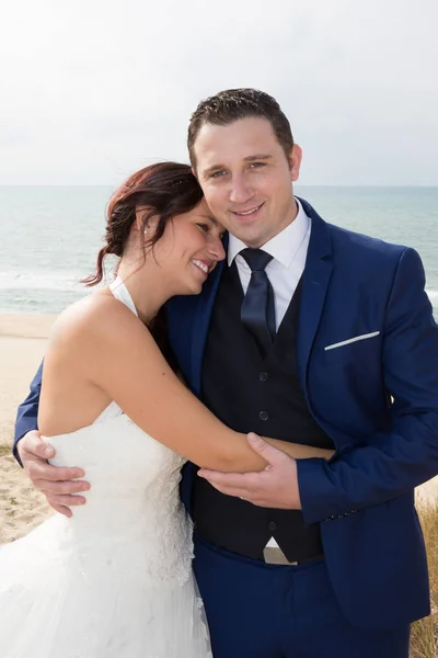 Nádherné a veselé manželský pár stojící na pláži — Stock fotografie