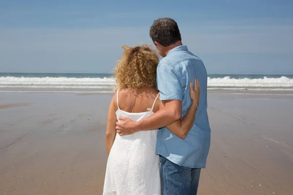 Пара прогулок по пляжу вместе в любви держась друг за друга . — стоковое фото