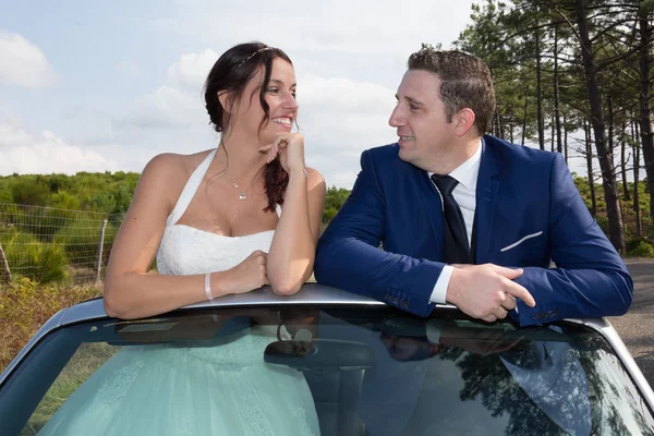 V lásce svatební pár stojící na svatební auto — Stock fotografie