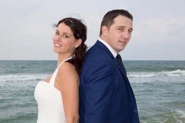 Casal na praia em vestido de noiva de volta para trás — Fotografia de Stock