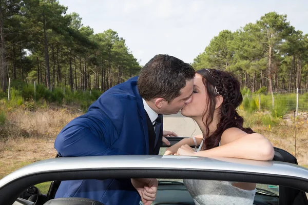 Bröllop par i kärlek kyssas i en cabriolet bil — Stockfoto