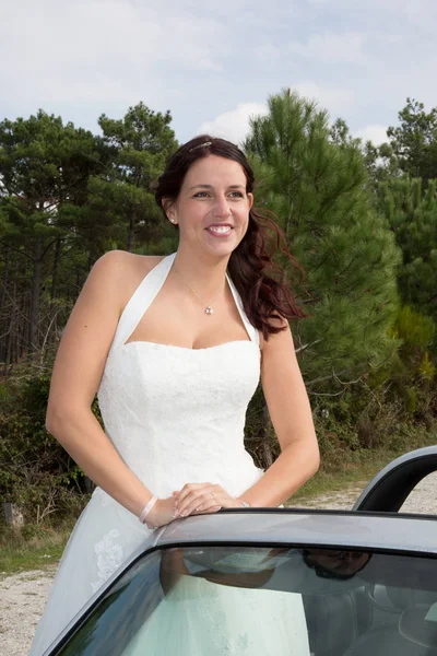 Mariée caucasienne debout dans la voiture et sourire à la caméra — Photo