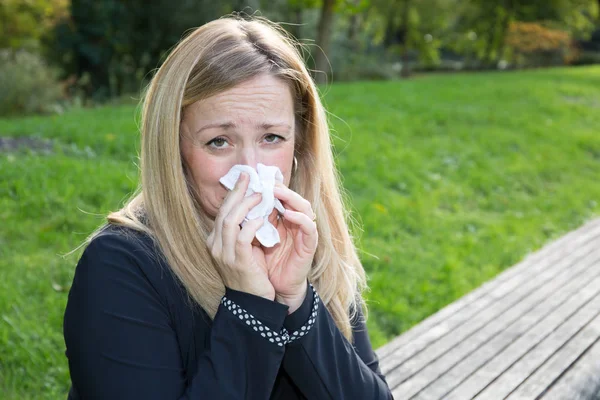 Pollen allergy, Springtime or a flu Woman sneezing in a tissue
