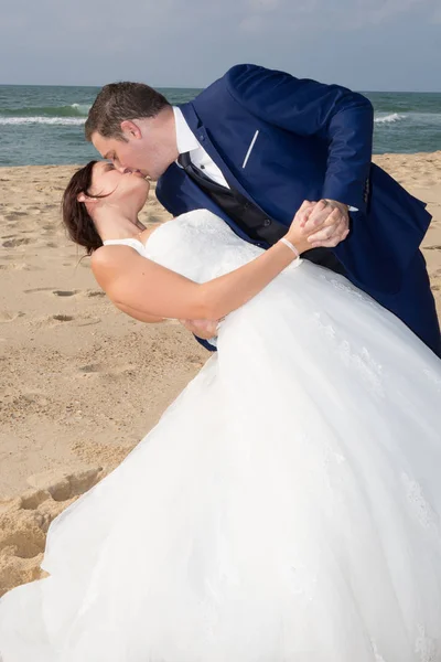 Nygifta dela en romantisk stund på stranden — Stockfoto