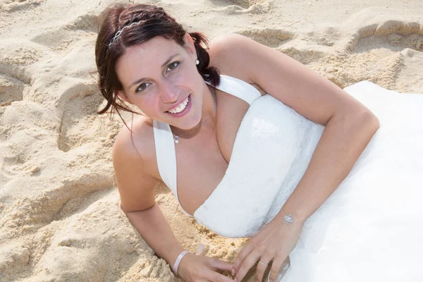 Charmante mariée est couchée sur le sable blanc — Photo