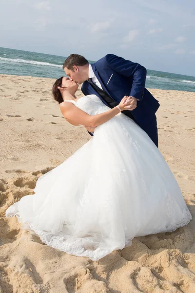 Nygifta dela en romantisk stund på stranden — Stockfoto