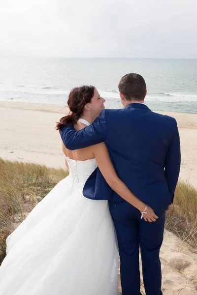 Bella coppia sulla spiaggia in abito da sposa — Foto Stock