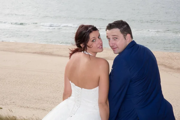 Casal encantador na praia em vestido de noiva — Fotografia de Stock