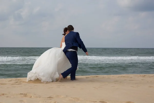 Boda pareja caminando en azul playa orilla —  Fotos de Stock