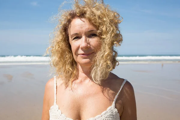 Жінка середнього віку відпочиває на пляжі біля моря — стокове фото