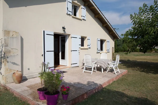 Vue de profil de la maison avec fenêtres bleues dans le jardin — Photo