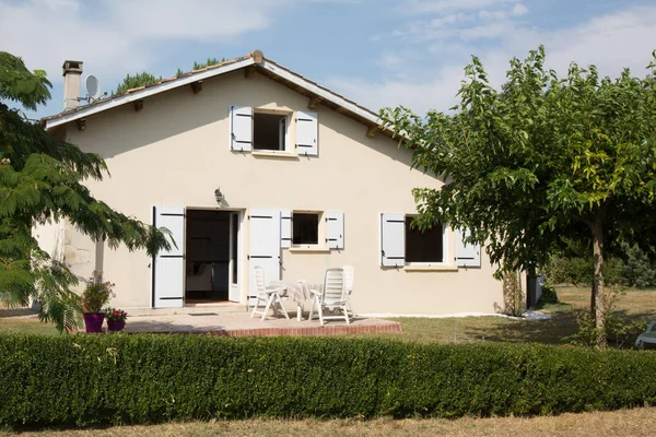 Maison familiale avec fenêtres bleues dans le jardin — Photo