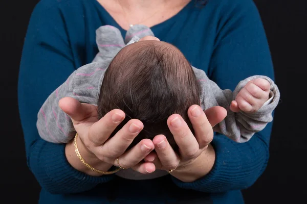 Porträt eines Säuglings an den Händen seiner Mutter — Stockfoto