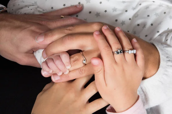 Руки отца, матери, дочери держат малыша на руках . — стоковое фото