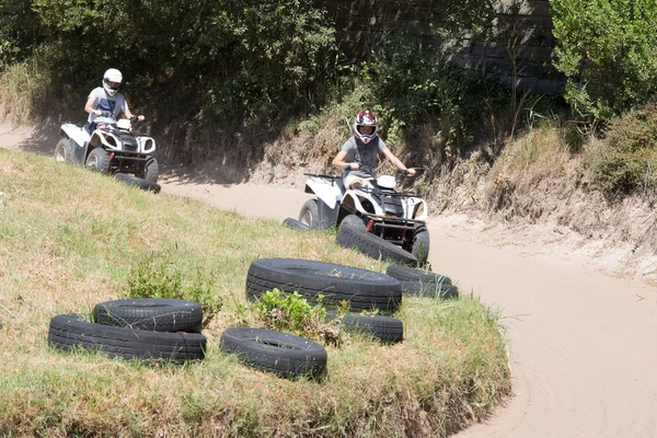 驾驶在道路上的人四辆自行车或 Atv — 图库照片