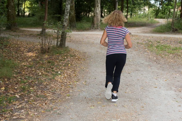 Бегущая женщина, бегающая в парке под солнцем красивым летом — стоковое фото