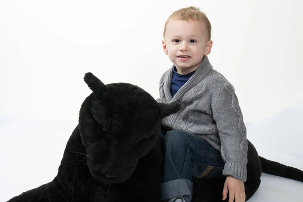 Маленький хлопчик грає з м'якою іграшкою пантери — стокове фото
