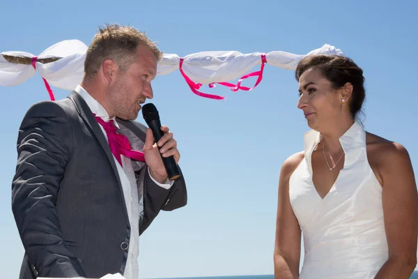 Счастливая супружеская пара стоит на пляже — стоковое фото