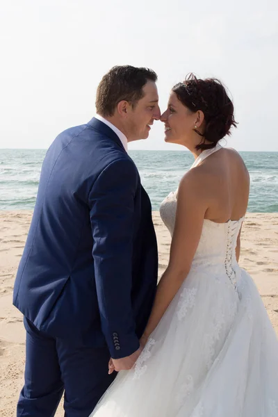 Kyss av kärlek av bröllopsparet på stranden sida — Stockfoto