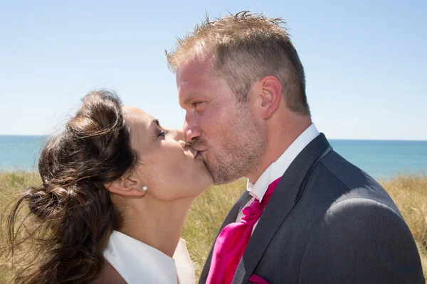 Свадебный поцелуй после свадьбы день на пляже океана — стоковое фото
