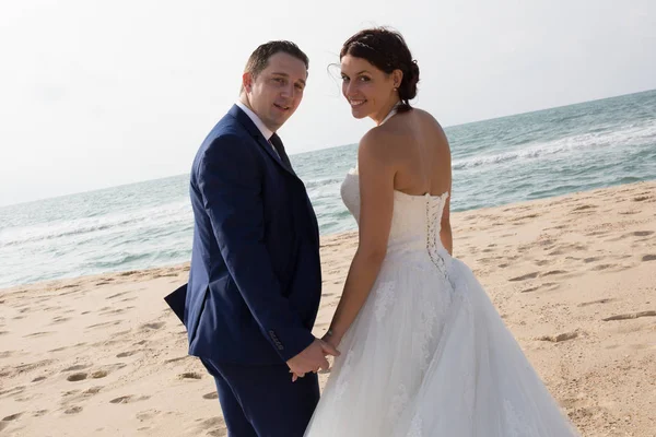 Casamento casal caucasiano no lado da praia andando na areia — Fotografia de Stock