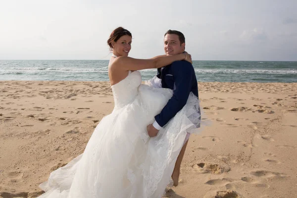 Abraço de casal de casamento na praia do mar após o casamento — Fotografia de Stock