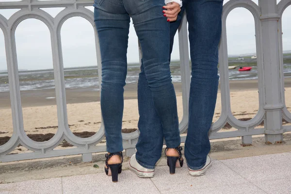 Pernas de um casal apaixonado na praia ou no mar durante as férias — Fotografia de Stock