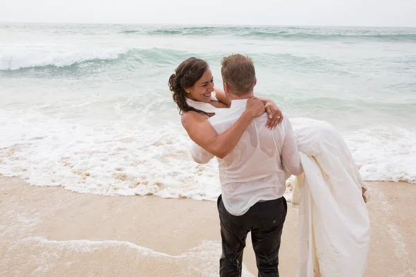 新娘和新郎在有乐趣在婚礼上海滩砂 — 图库照片