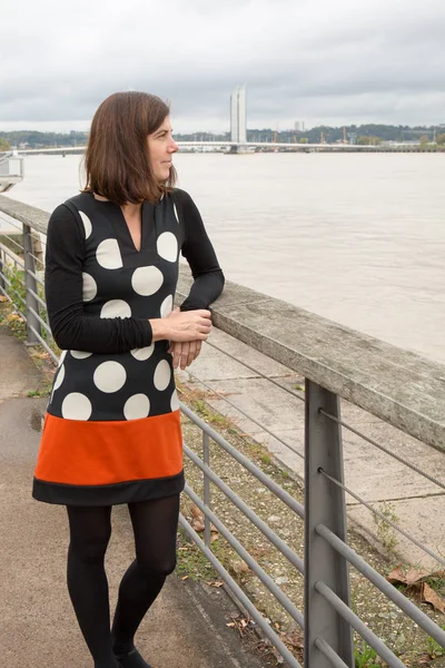 Um turismo de mulher perto de um rio em city tour com vestido de moda — Fotografia de Stock