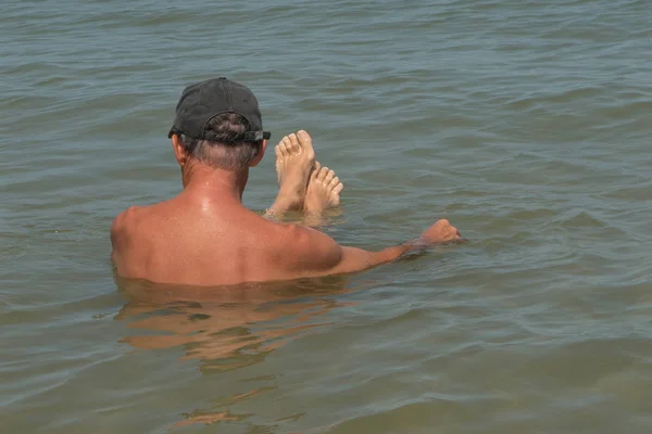 ビーチ湖で風呂で年配の男性の背面図 — ストック写真