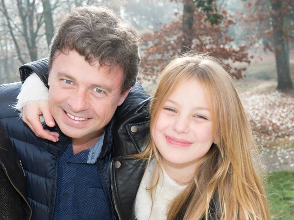 daddy with daughter in love, hug outdoor in winter with blonde girl