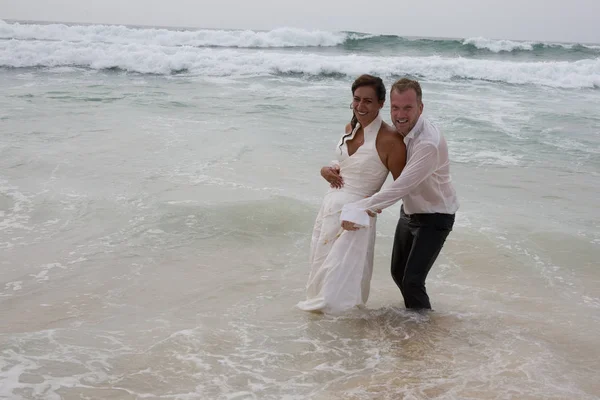 Liebespaar nach Hochzeit im Strandwasser des verliebten Ozeans — Stockfoto