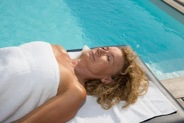 Bionda donna matura massaggio all'aperto in piscina — Foto Stock