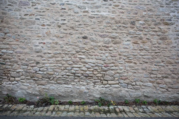 In the village street, an ancient stone wall with the floor down — Stock Photo, Image