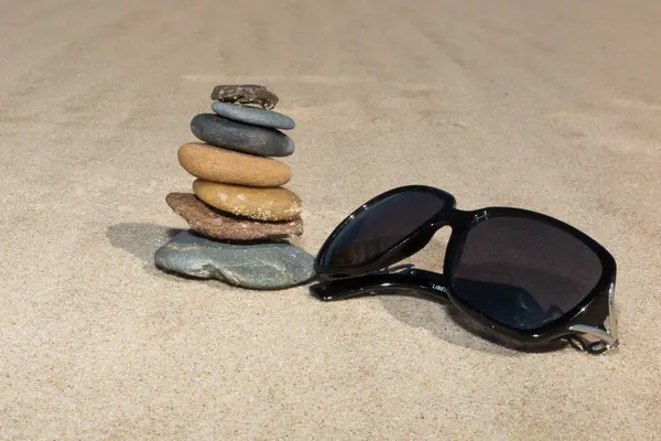 Piramida z kamienia na plaży i okulary na wakacje symbol i relaks — Zdjęcie stockowe