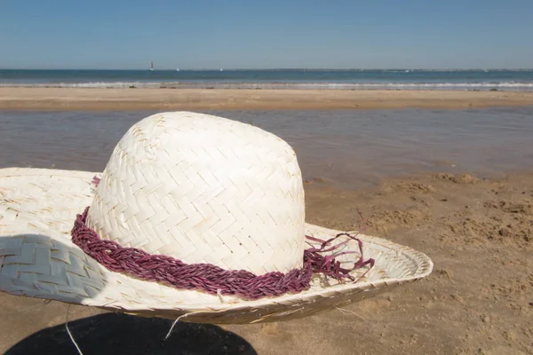 Un sombrero colocado en la arena de la playa en símbolo de vacaciones y relajación — Foto de Stock