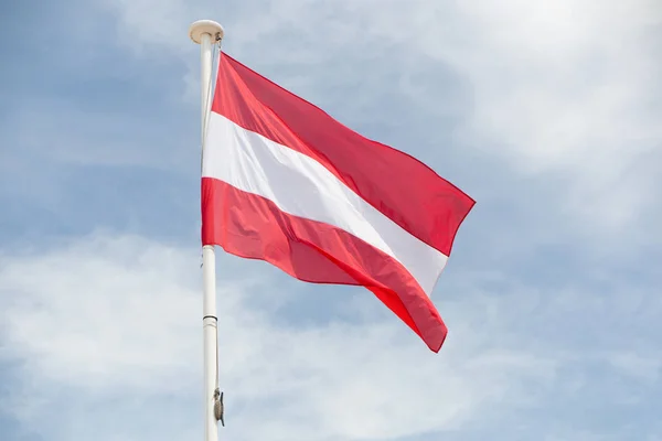 Bandera austriaca flota en el viento colgando de un mástil —  Fotos de Stock
