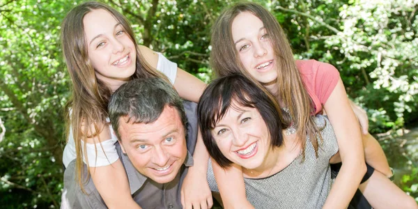 Glückliche Familie mit Eltern und zwei jugendlichen Zwillingsmädchen — Stockfoto