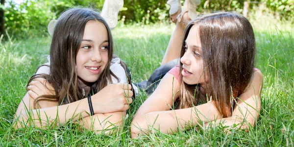 Front view of young girls laying on the grass — Stock Photo, Image