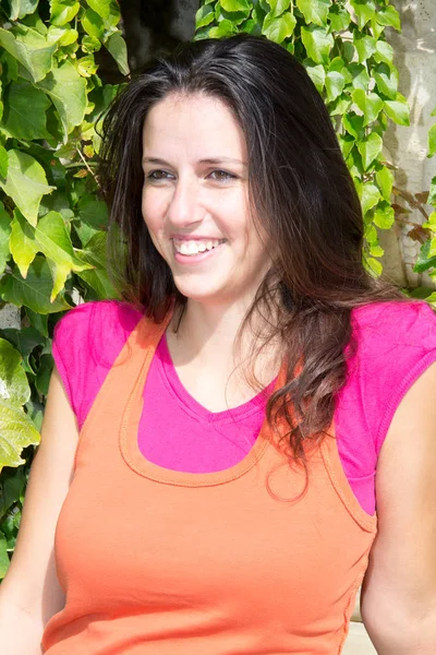 Schöne junge Frau mit ihrem orangefarbenen und rosa Oberteil — Stockfoto