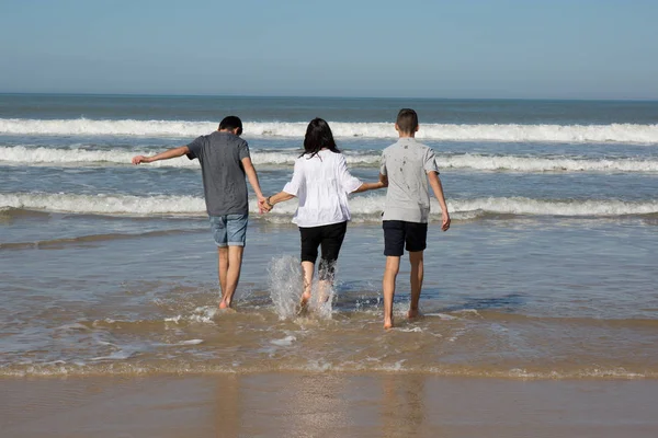 Divorced mother having fun with her two teenage boy on the beach — Stock Photo, Image