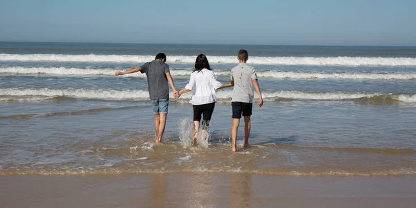 Casal à beira-mar na praia com seu menino adolescente — Fotografia de Stock