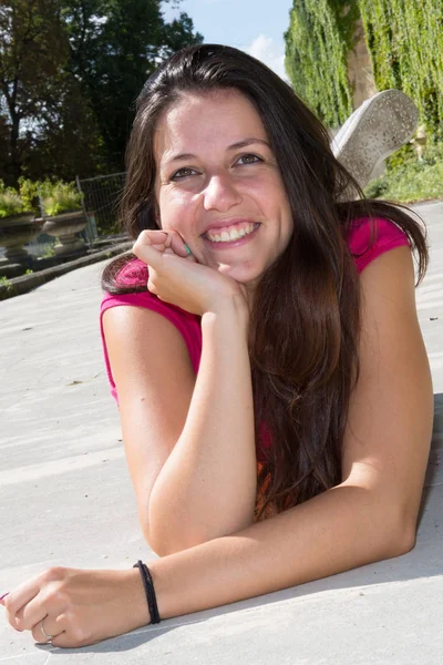 Muito bonita jovem deitada no chão com um grande sorriso — Fotografia de Stock