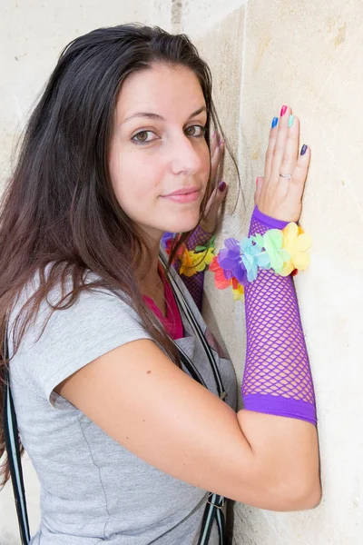 Schöne junge Frau mit langen Haaren mit einem fluoreszierenden violetten Handschuh — Stockfoto
