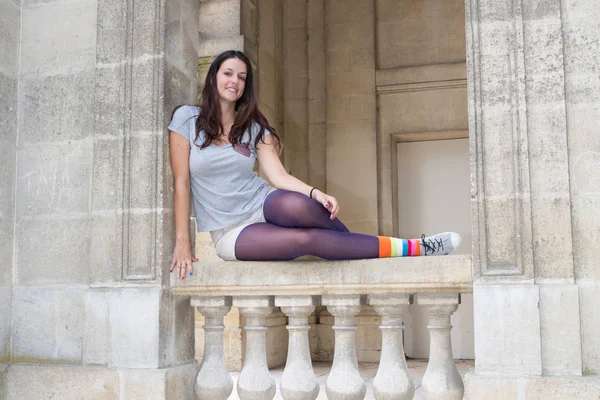 Belle jeune femme assise sur une rampe d'un vieux bâtiment de la ville en Europe — Photo