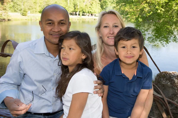 Schöne multiethnische Familien am See mit Eltern und zwei Kindern — Stockfoto